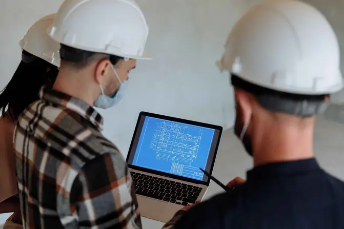 Construction electrician in hard hat and safety vest working in a training workshop