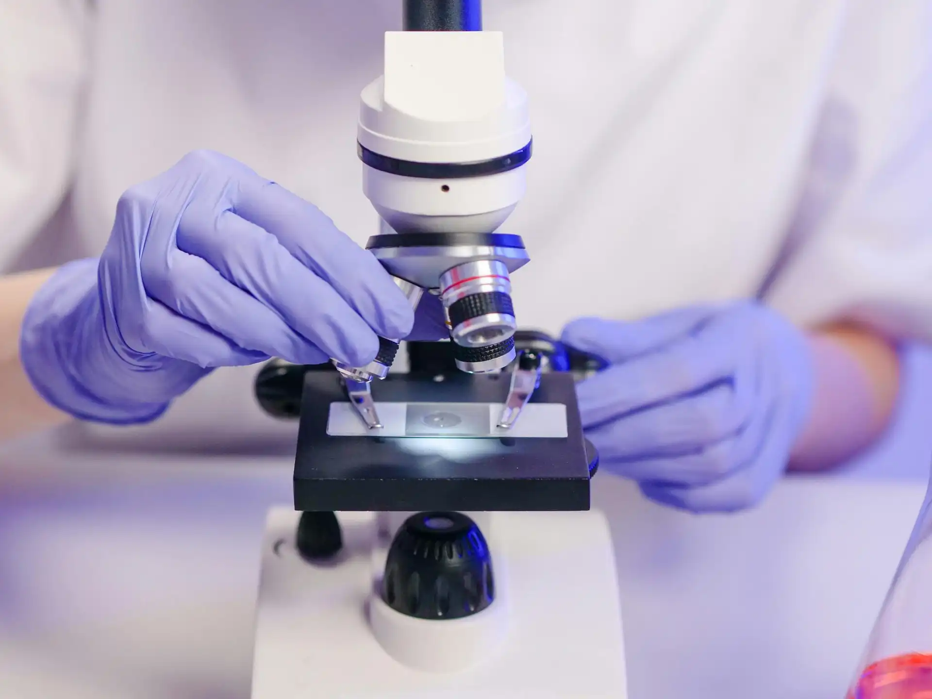 Scientist operating a microscope in a modern medical laboratory